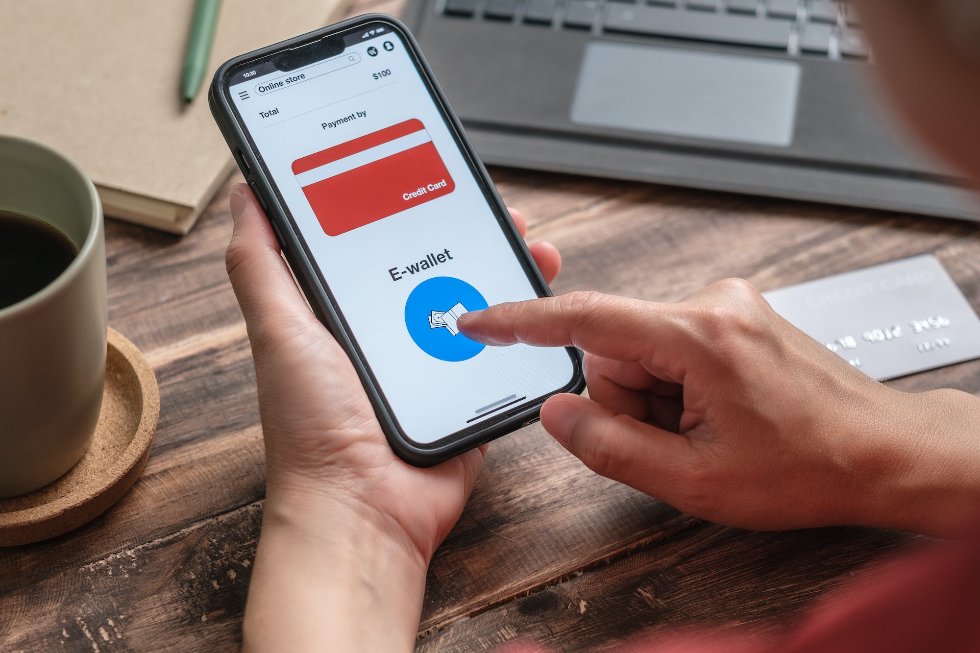 close up woman hand choosing e-wallet instead of credit card shopping online on mobile app at home