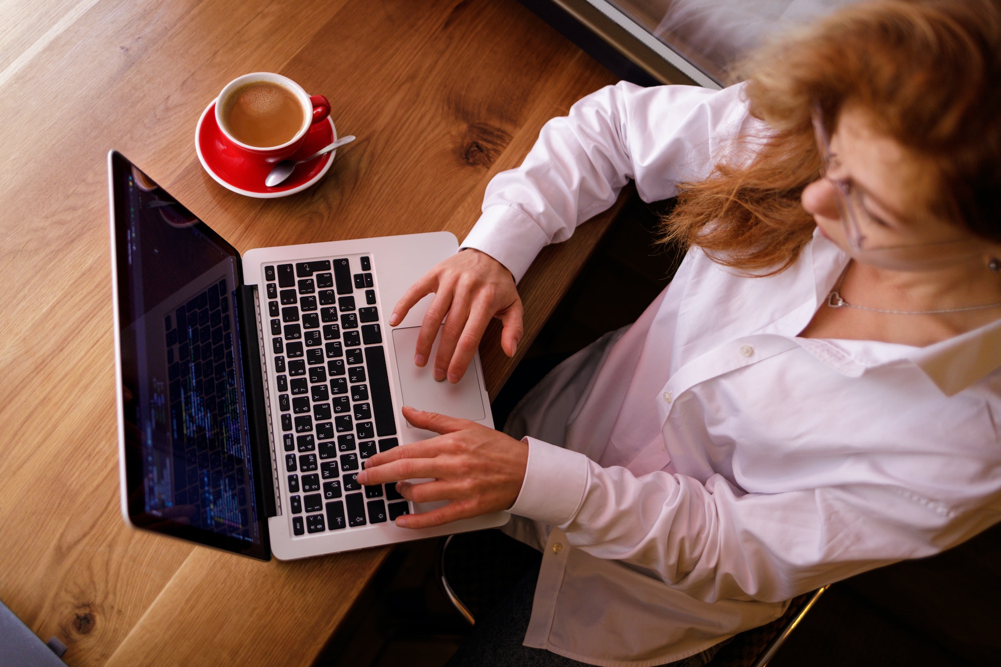 Young woman programming on laptop at cafe